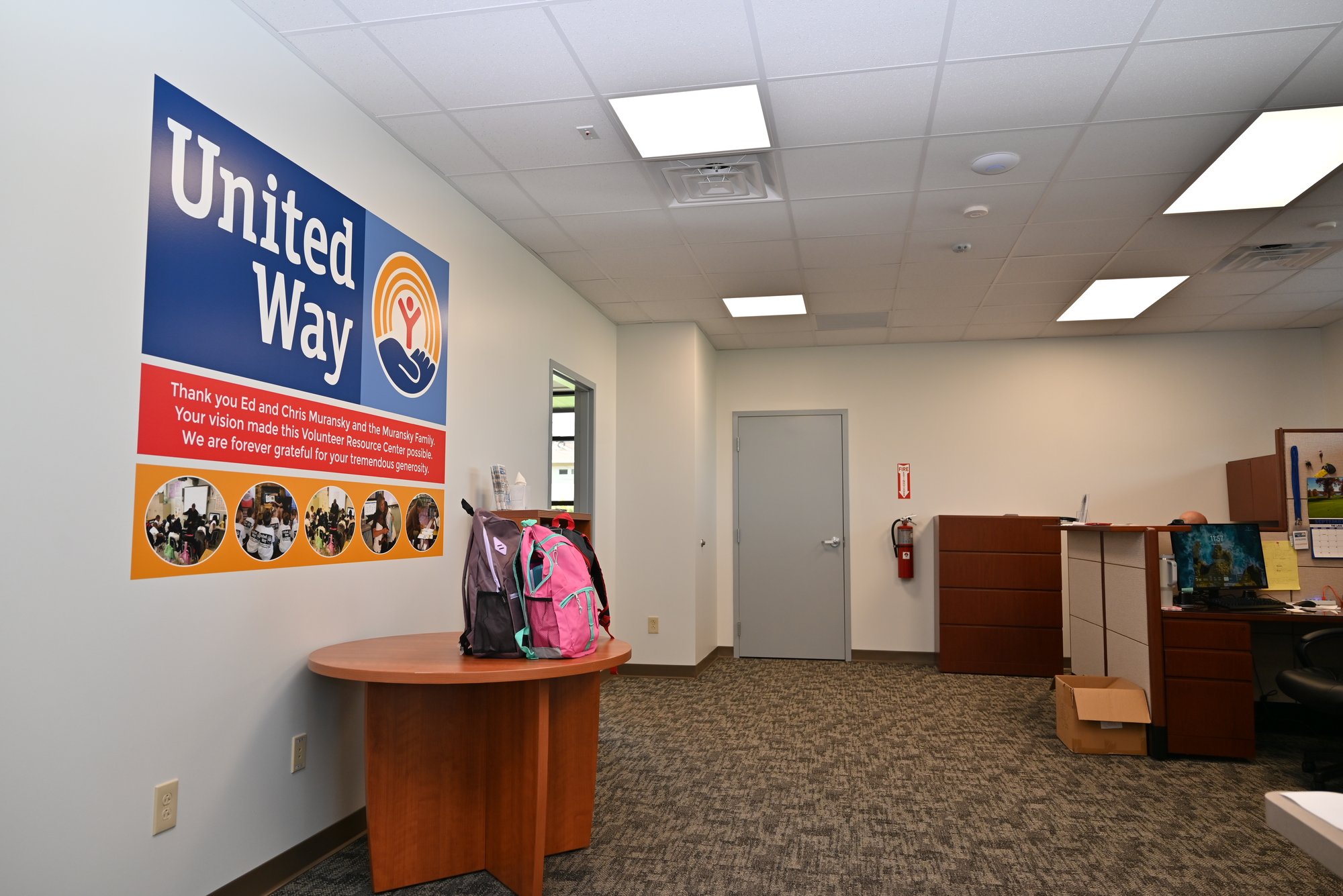 Interior of United Way Volunteer Resource Center with office desks and company sign, highlighting the completed workspace design.